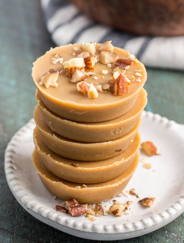 A stack of low carb peanut butter fudge pieces on a white plate. 