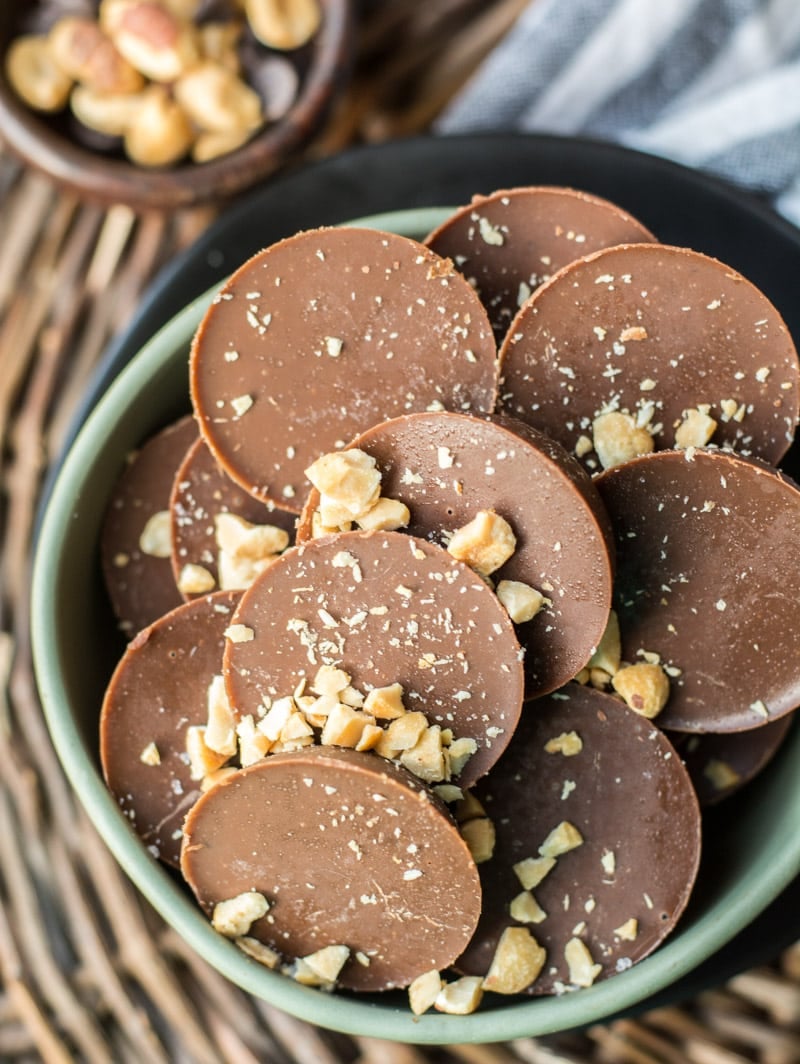 Overhead view of chocolate peanut butter fat bombs piled in a green bowl. 