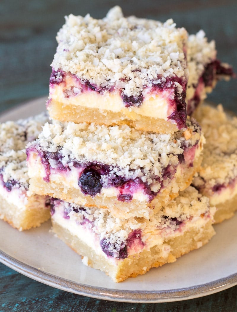 A stack of blueberry cheesecake bars on a plate