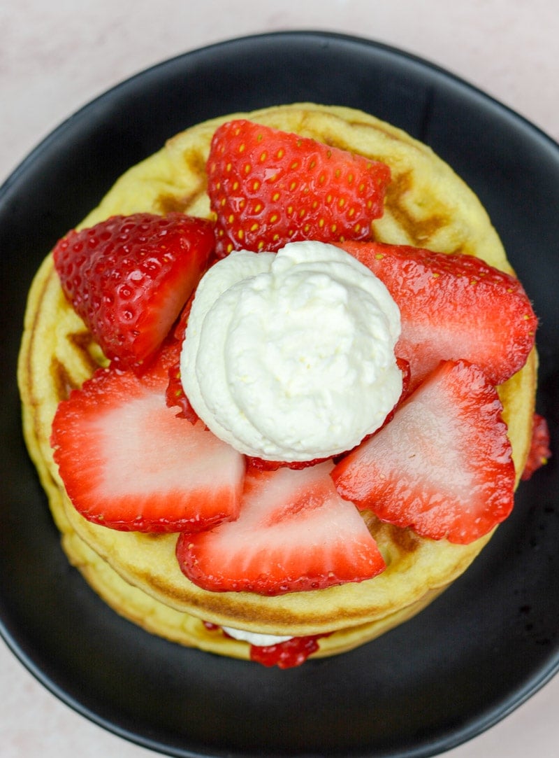 overhead image of strawberry shortcake waffles on a black plate