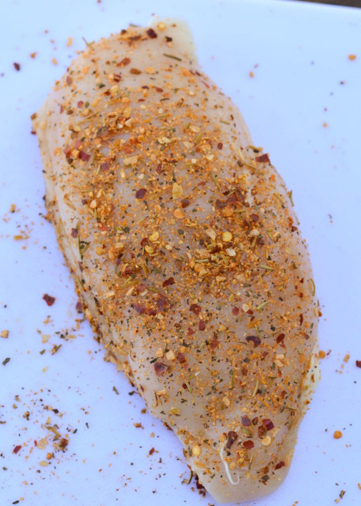 Fold the top of the chicken breast back over and secure it closed with a toothpick. Rub the chicken with the tasty Cajun seasoning, making sure it is well covered.