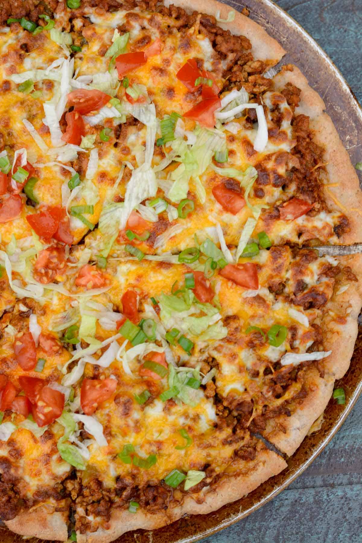 An overhead shot of taco pizza on a pan