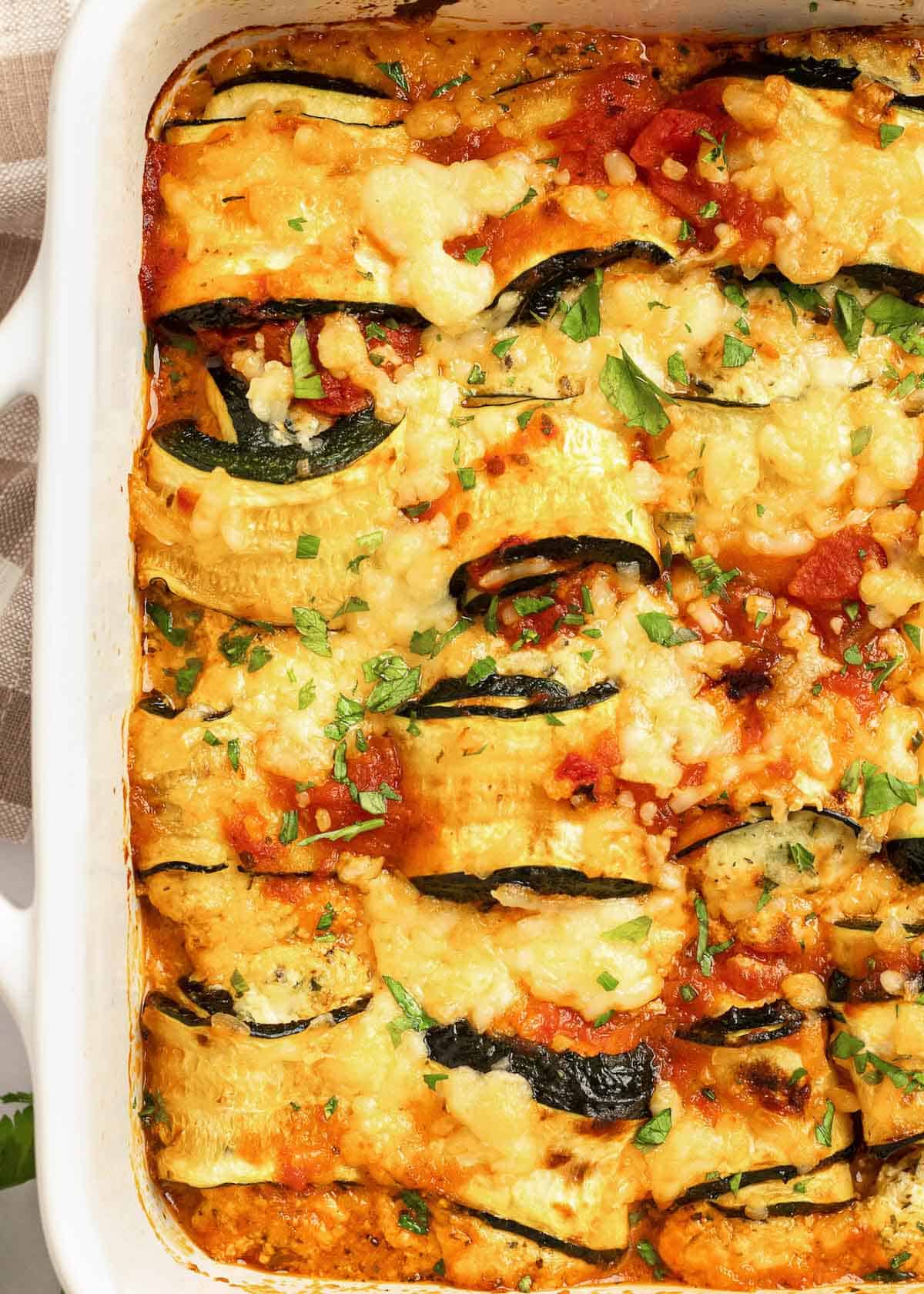 overhead image of zucchini lasagna rolls in a white baking dish