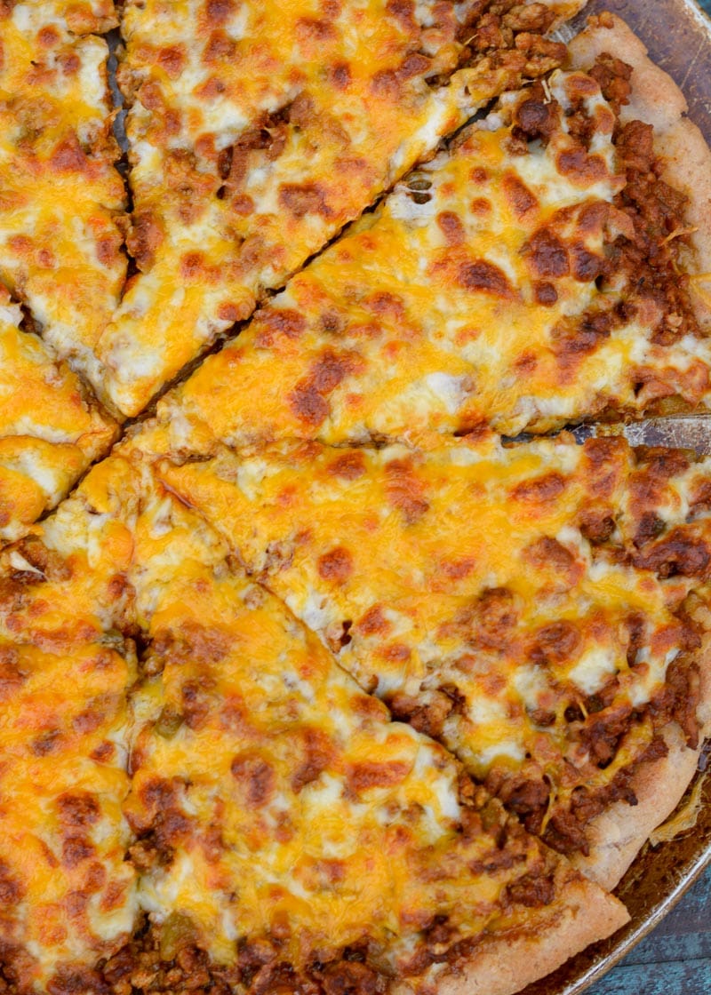 Enjoy a slice of cheesy Taco Pizza topped with all of your favorite Mexican fixings! This low carb pizza recipe has just 5 net carbs per slice and is loaded with flavor!