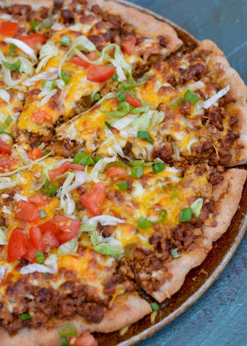 Enjoy a slice of cheesy Taco Pizza topped with all of your favorite Mexican fixings! This low carb pizza recipe has just 5 net carbs per slice and is loaded with flavor!