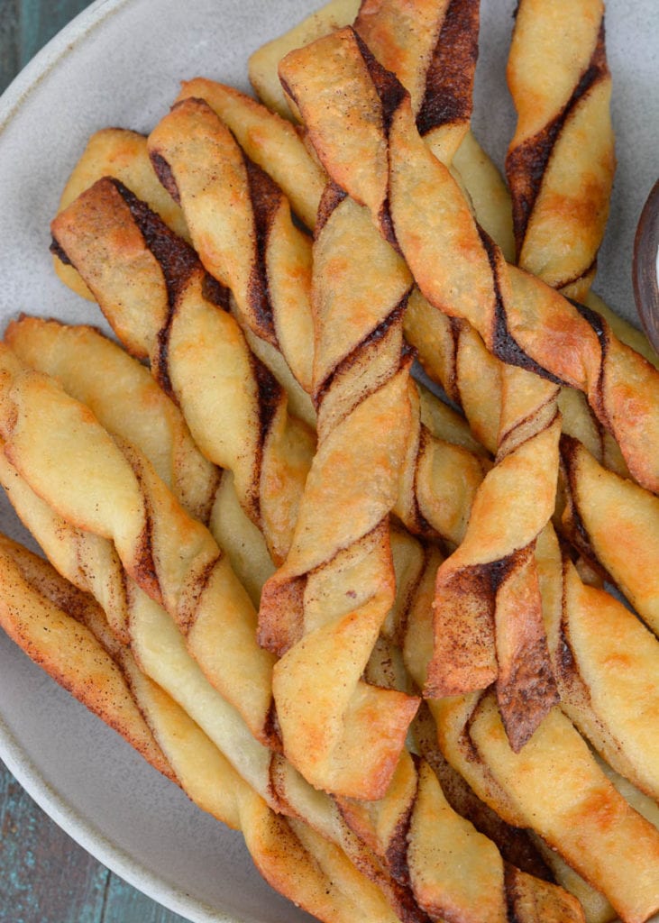 These easy Keto Cinnamon Twists have a delicious keto cream cheese dipping sauce for the best gluten free + keto snack! Enjoy two twists and frosting for just 3 net carbs!