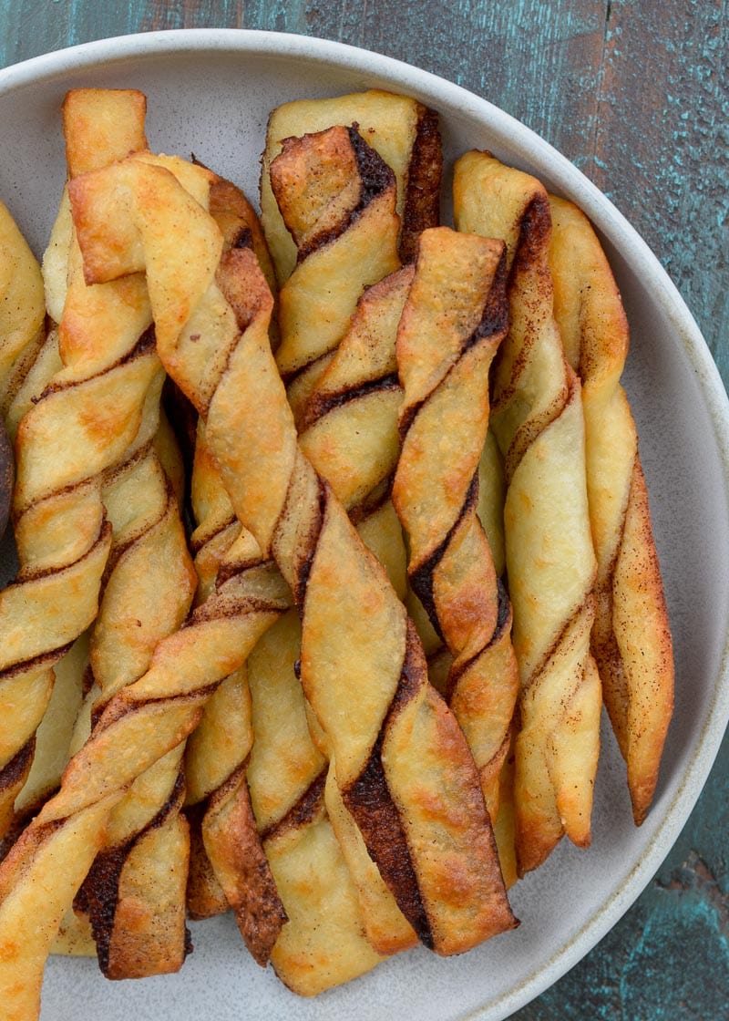 These easy Keto Cinnamon Twists have a delicious keto cream cheese dipping sauce for the best gluten free + keto snack! Enjoy two twists and frosting for just 3 net carbs!