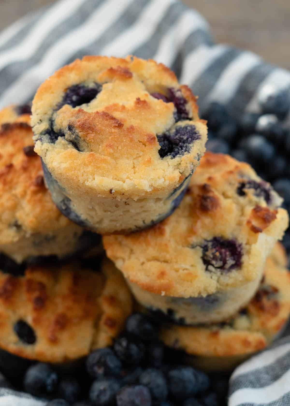 blueberry muffins in a bowl with a stripe napkin