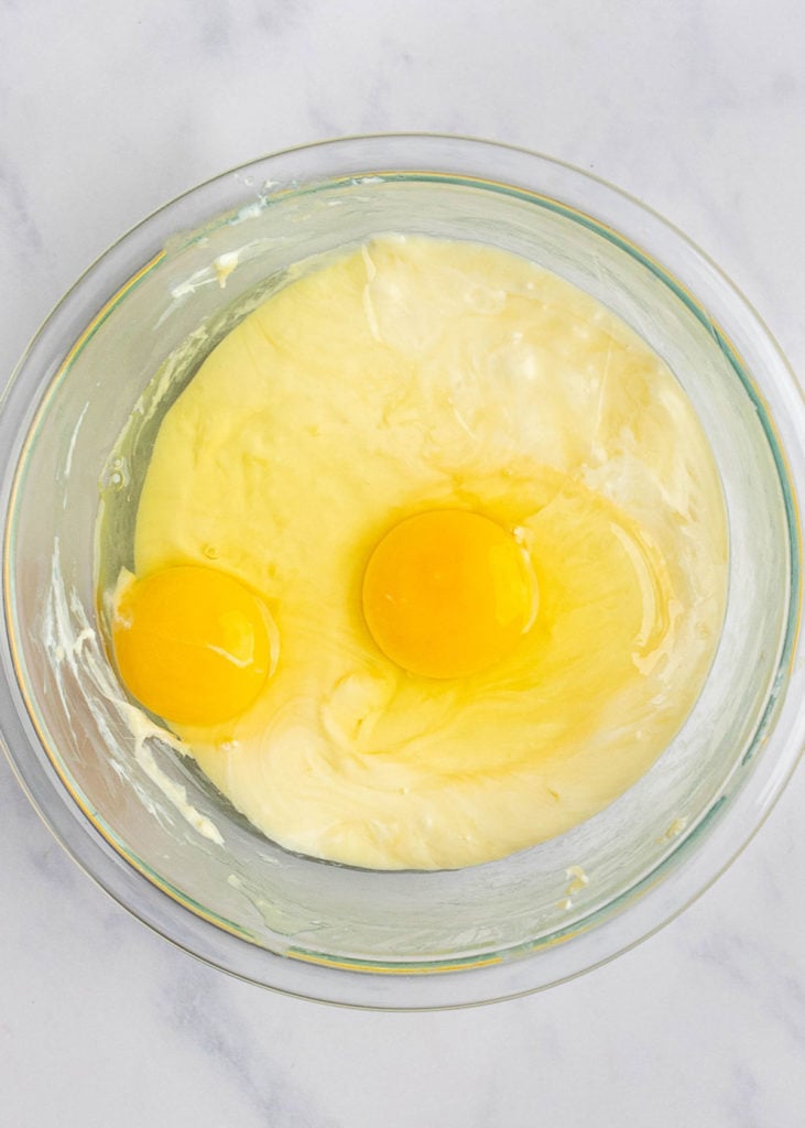 A mixing bowl with melted cheese in it, topped with two eggs