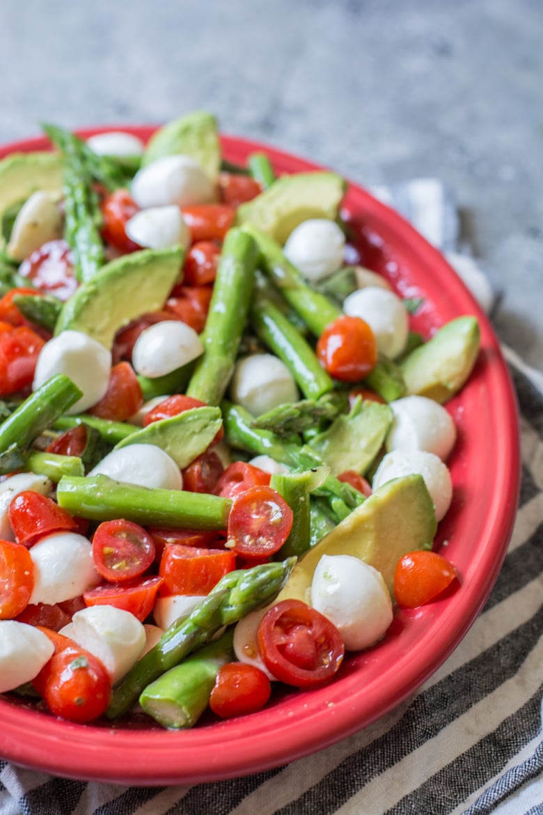 This Cold Asparagus Salad is made with cherry tomatoes, avocado, mozzarella, and fresh basil. All drizzled in a creamy lemon vinaigrette! The perfect low-carb summer salad! 