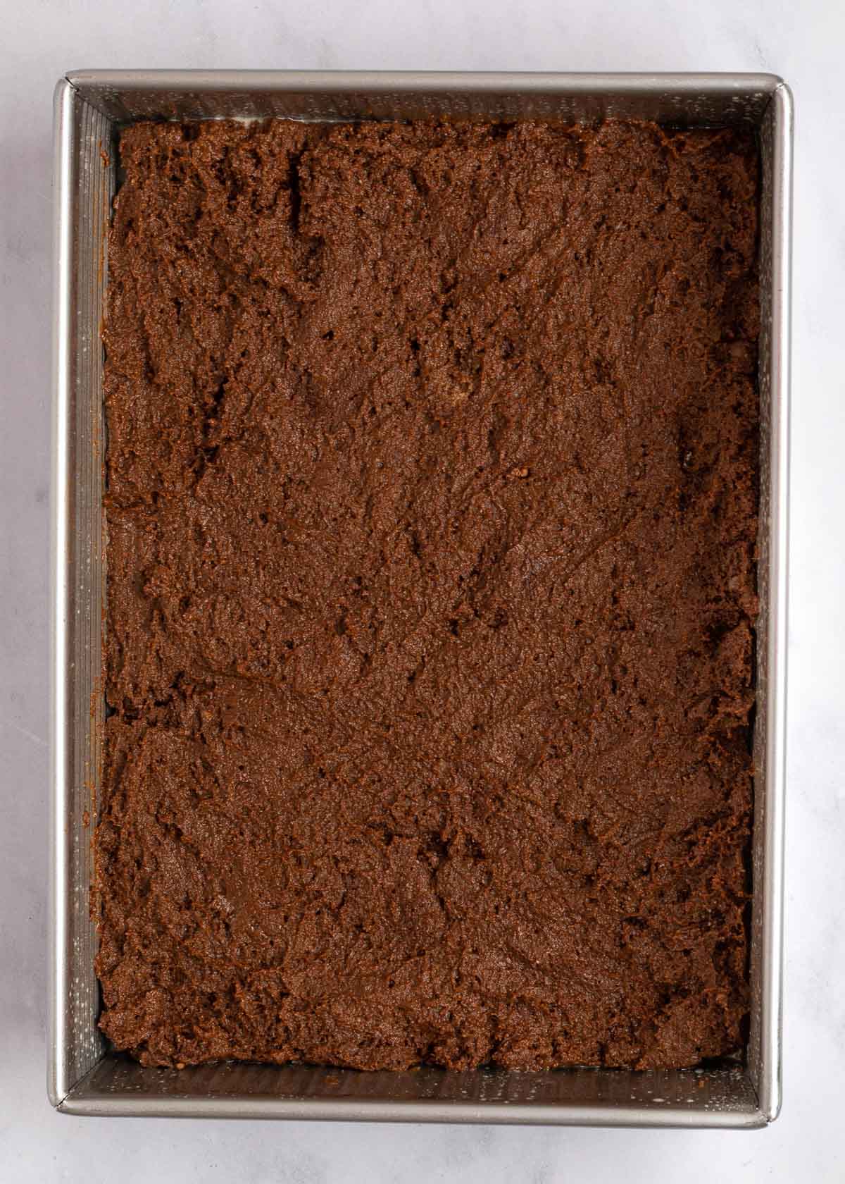 Overhead view of an unbaked chocolate cake in a cake pan