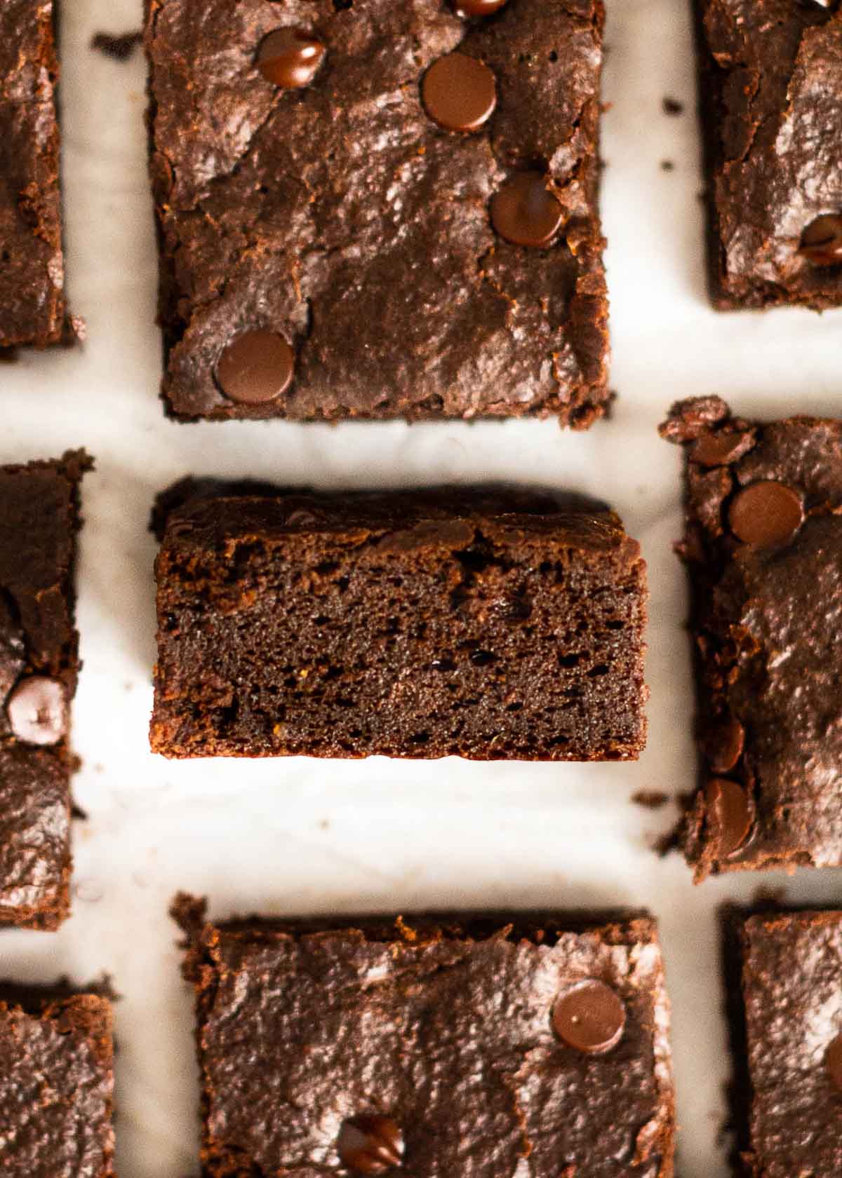 Close up of a brownie square on its side, next to other brownie squares