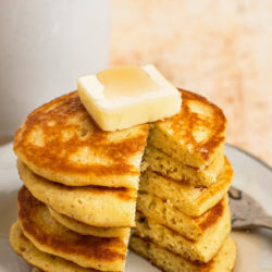 Stack of pancakes on plate with coffee