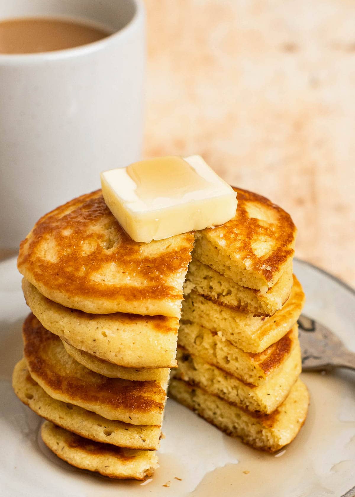 Stack of pancakes on plate with coffee