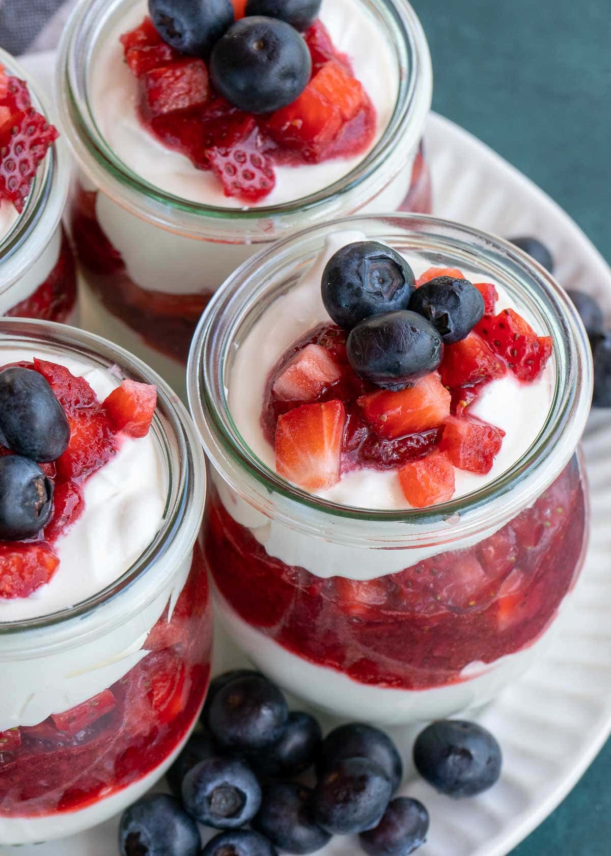 This festive No Bake Cheesecake Parfait recipe is the perfect summer treat! An indulgent cheesecake layer is paired with berries for a low-carb dessert perfect for potlucks and parties!