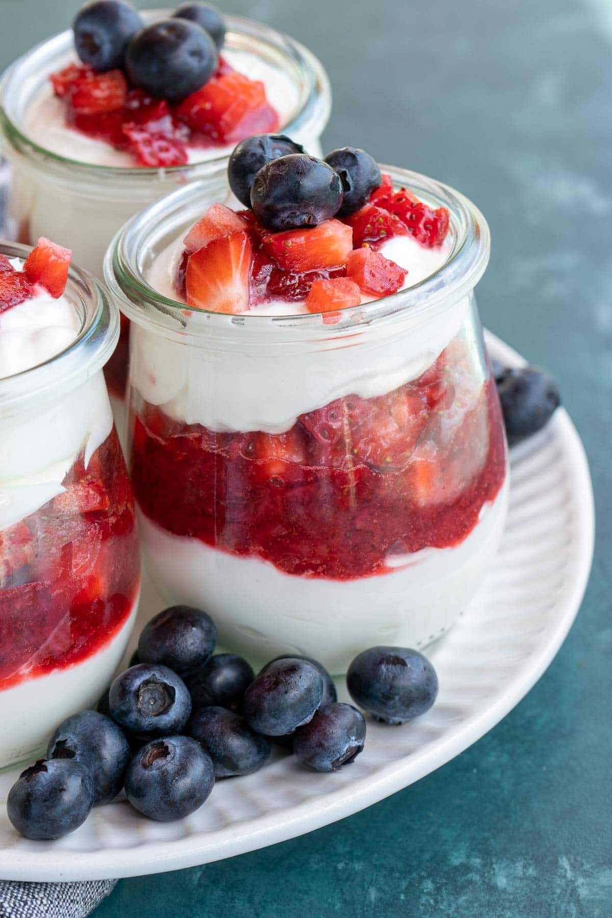 This festive No Bake Cheesecake Parfait recipe is the perfect summer treat! An indulgent cheesecake layer is paired with berries for a low-carb dessert perfect for potlucks and parties!