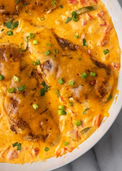 Close up of chicken breasts covered in melted cheese and scallions