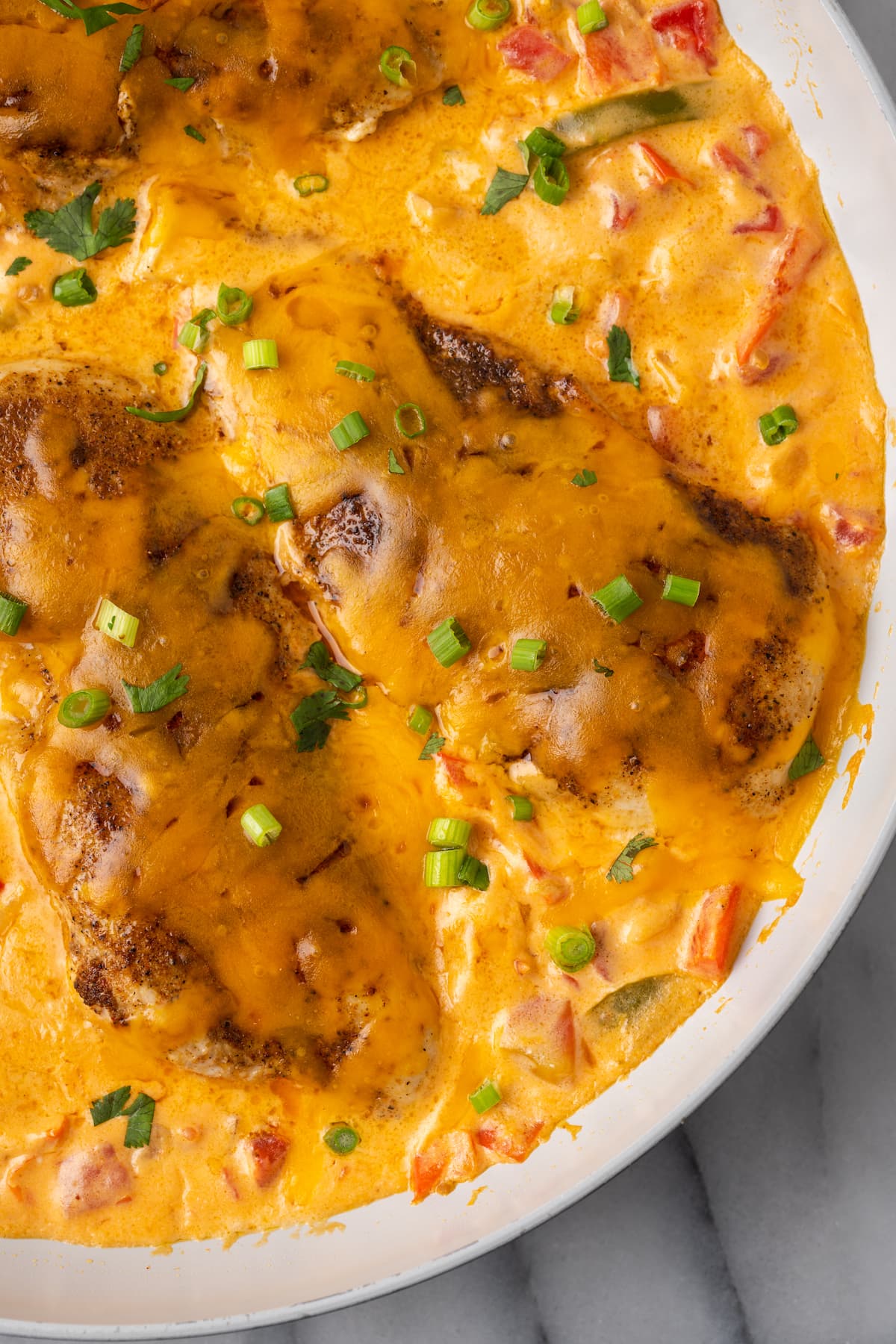 This Santa Fe Chicken is a one-pan recipe packed with your favorite southwestern flavors. Juicy seasoned chicken is paired with peppers, onions, and tomatoes in a creamy, cheesy sauce!