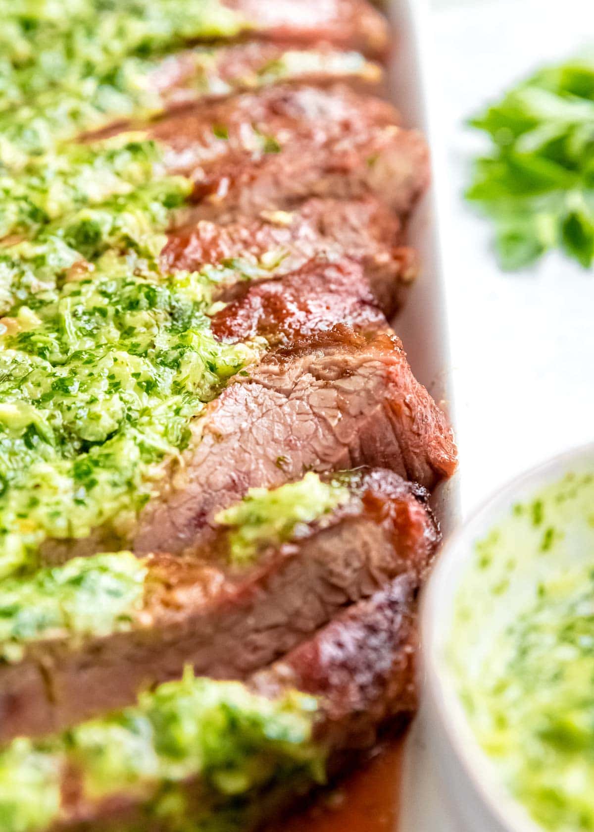 Juicy marinated Flank Steak is grilled to perfection and topped with zesty homemade Chimichurri sauce! This low-carb recipe is perfect for cookouts, parties, or a delicious weekend meal!