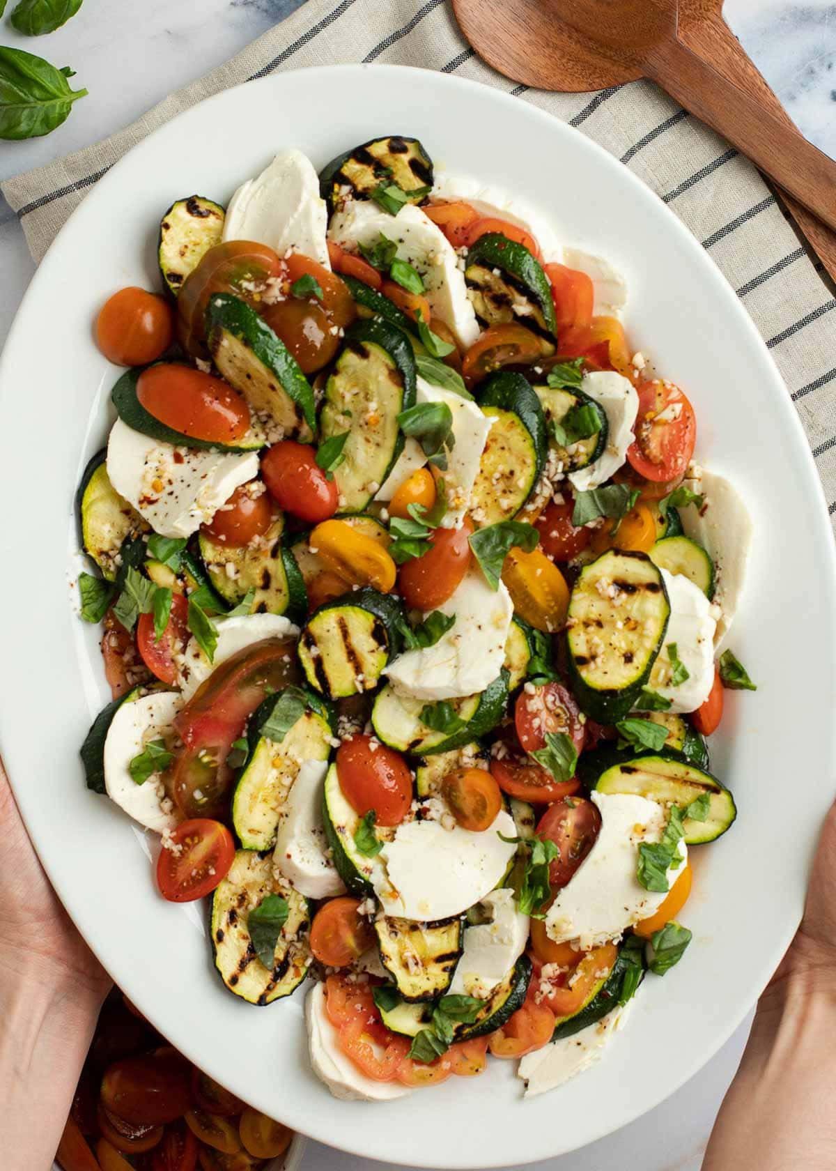 This Grilled Zucchini Salad with a homemade red wine vinaigrette will be your repeat meal of the summer! This healthy recipe is ready in under 30 minutes and loaded with fresh mozzarella and tender veggies.