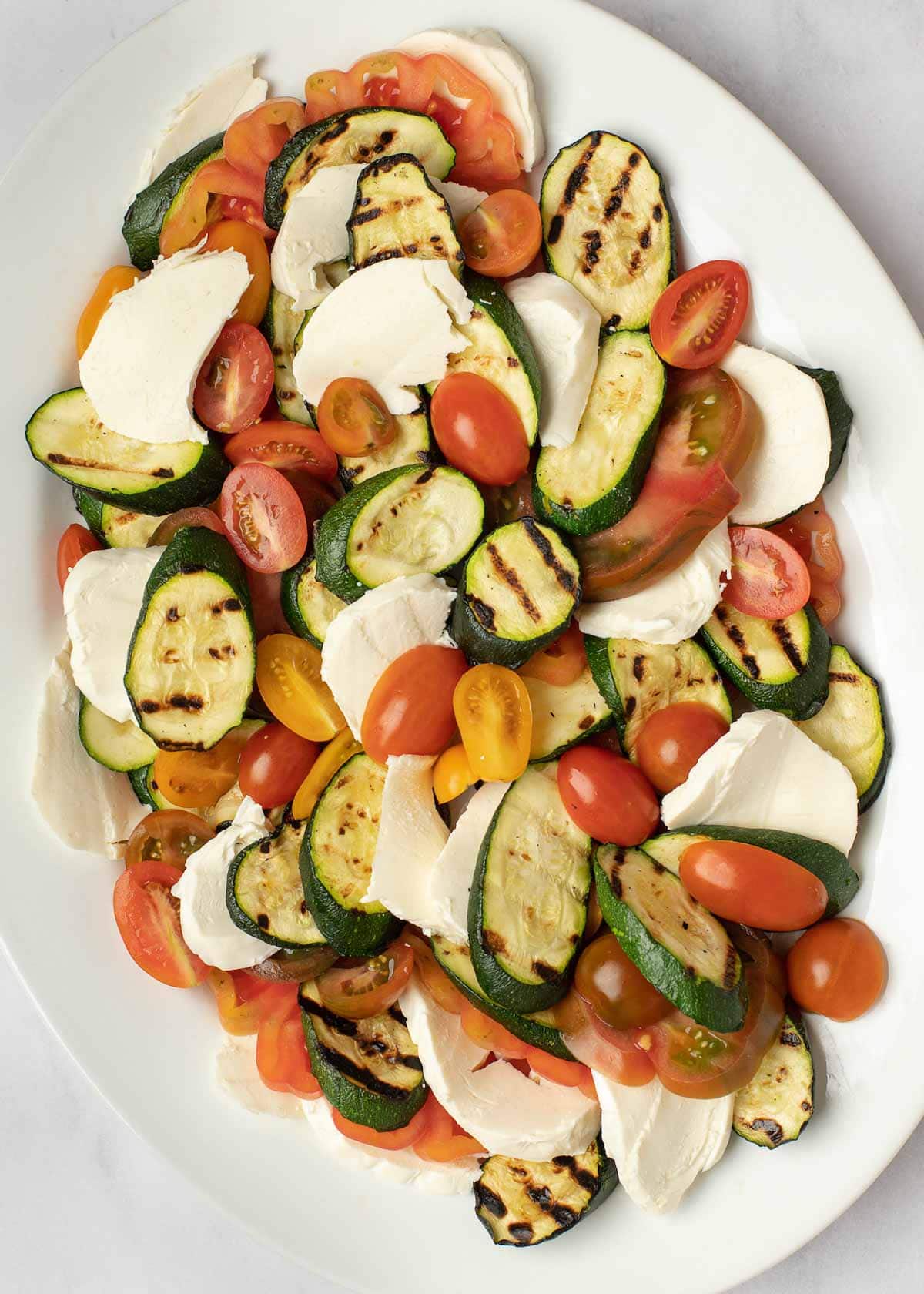 This Grilled Zucchini Salad with a homemade red wine vinaigrette will be your repeat meal of the summer! This healthy recipe is ready in under 30 minutes, loaded with fresh mozzarella and tender veggies, and has fewer than 5 net carbs.