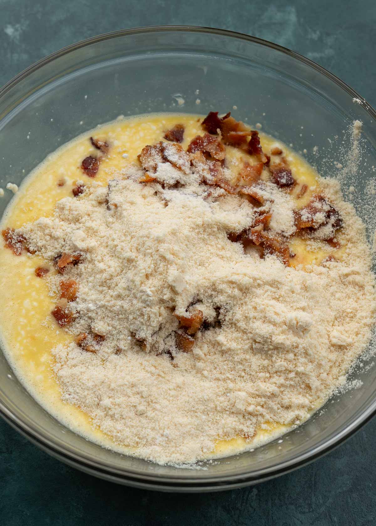 bacon egg and cheese muffin ingredients in a clear mixing bowl