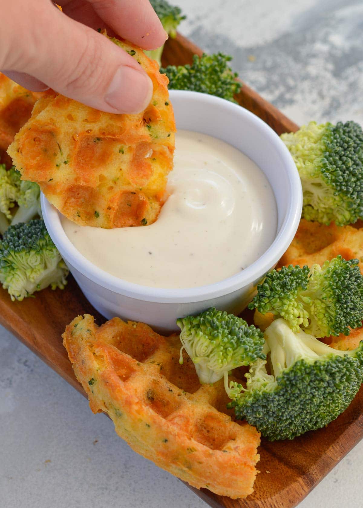 broccoli cheddar chaffle being dipped in dressing
