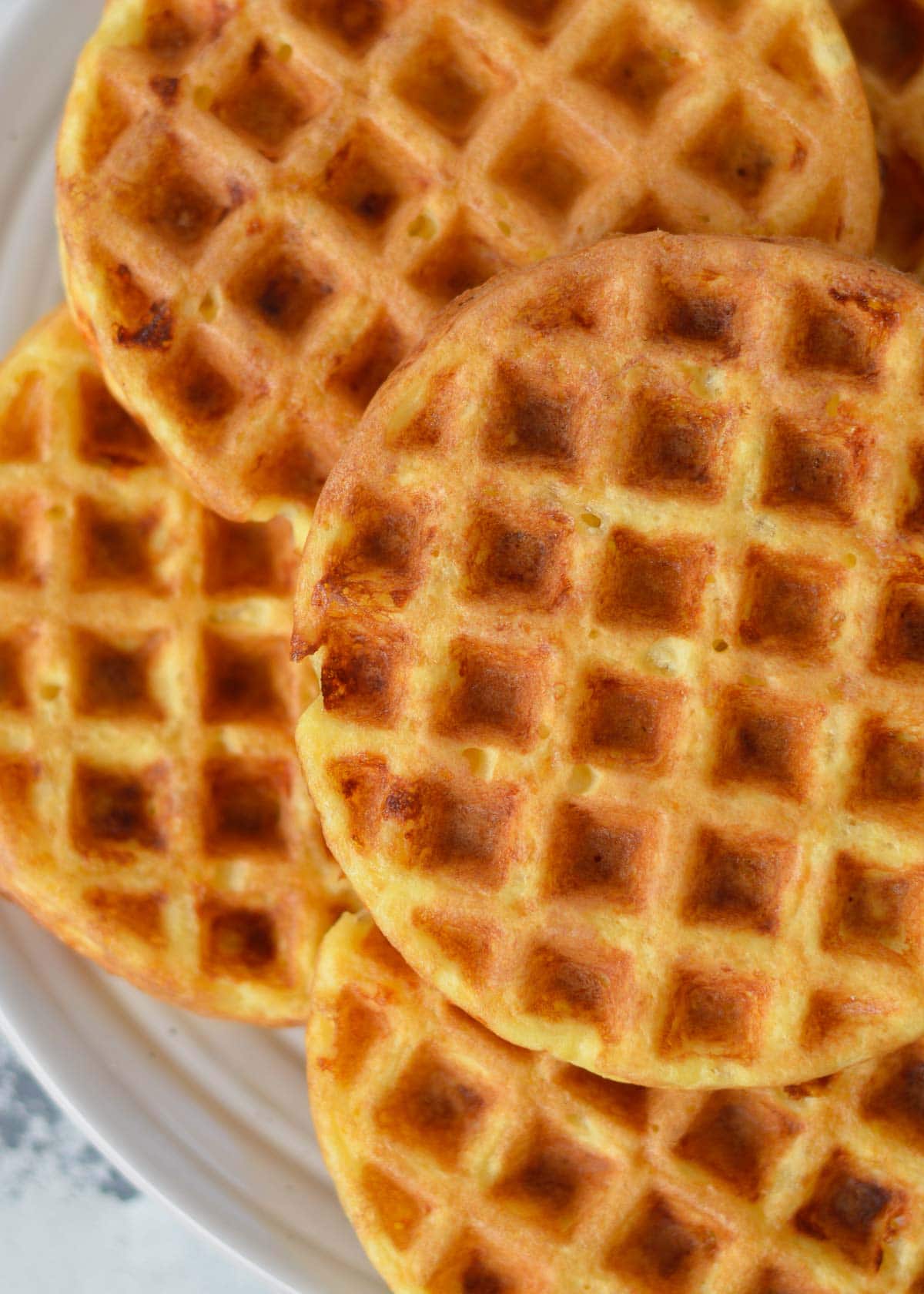 several coconut flour chaffles on a white plate