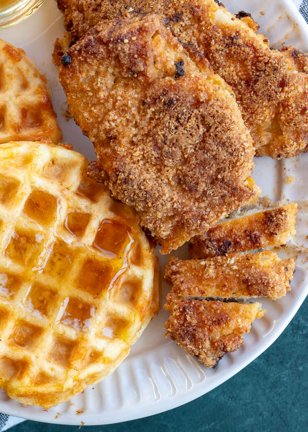 a plate f crispy breaded chicken sliced with a waffle 