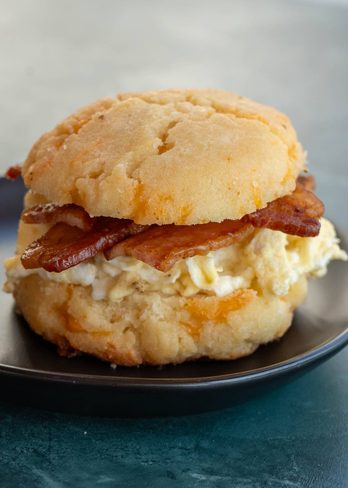 keto bacon, egg, and biscuit on a black plate