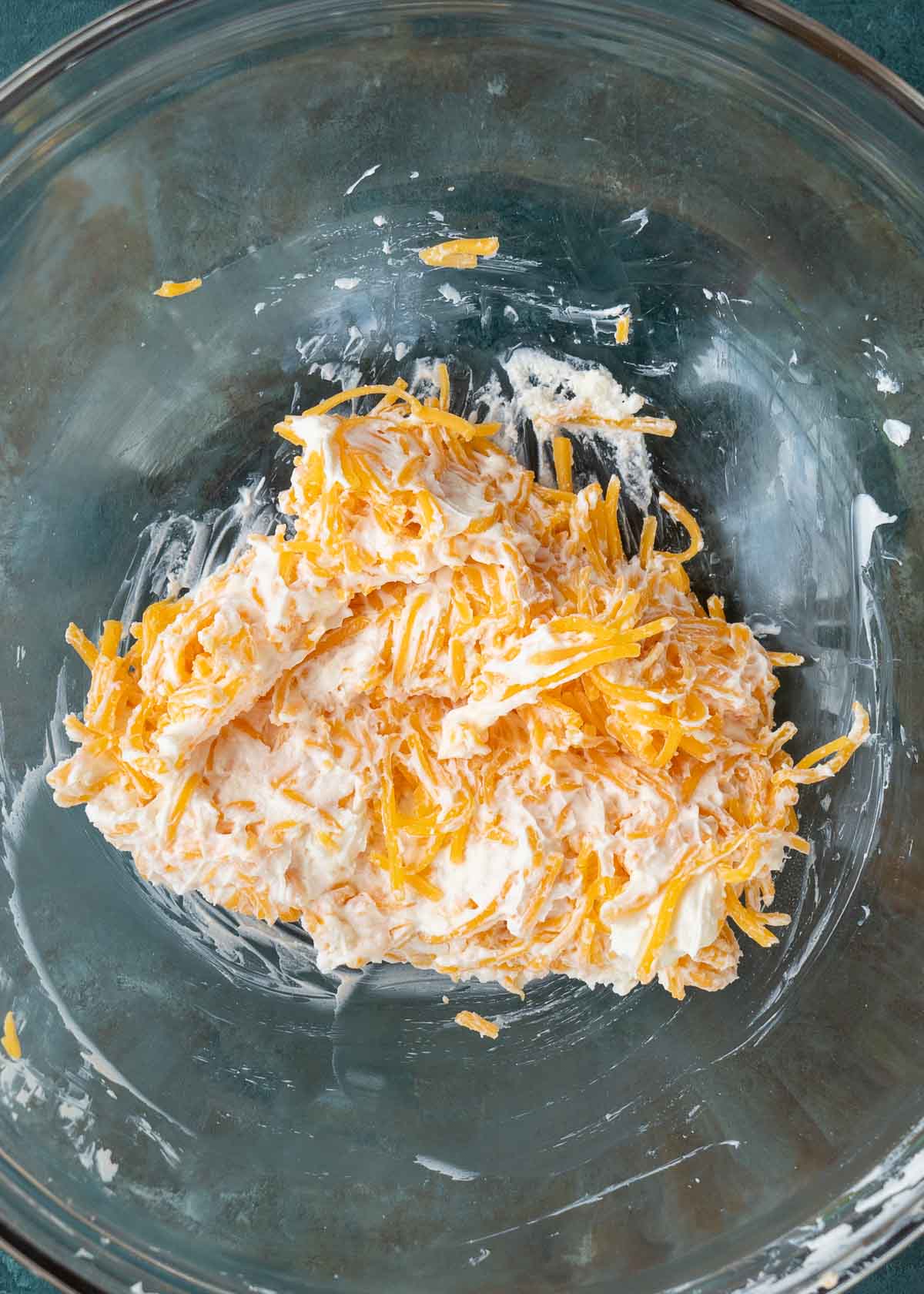 shredded cheese and cream cheese in bowl