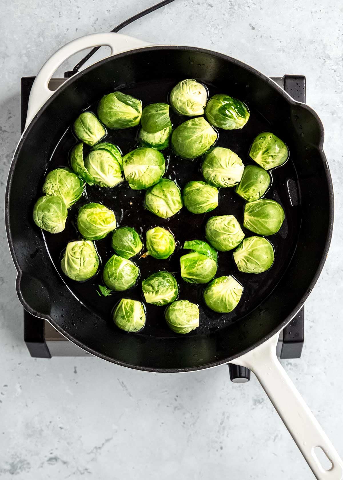 brussels sprouts cooking in a single layer, cut side down