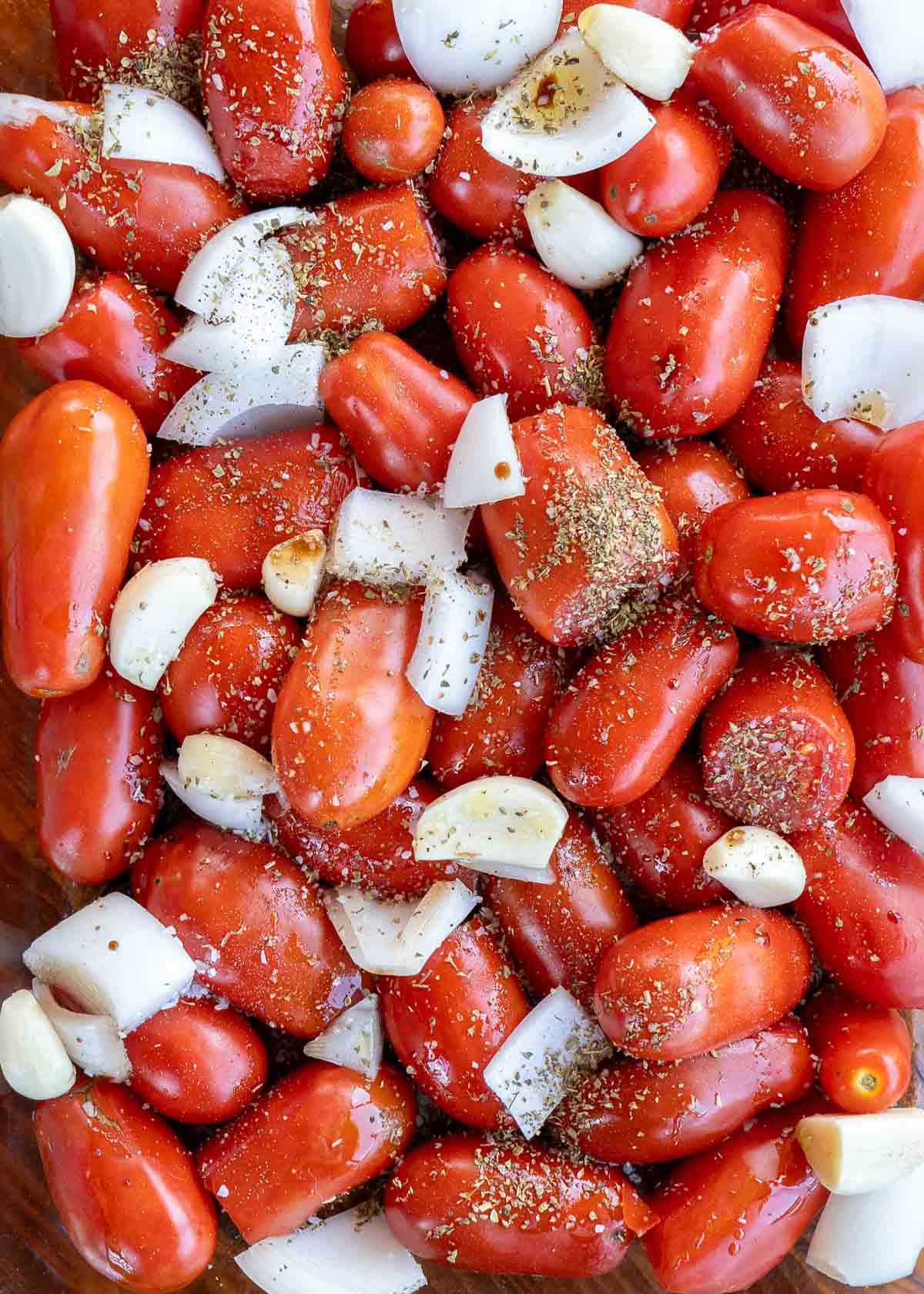 an overhead shot of fresh tomatoes, onion and garlic.