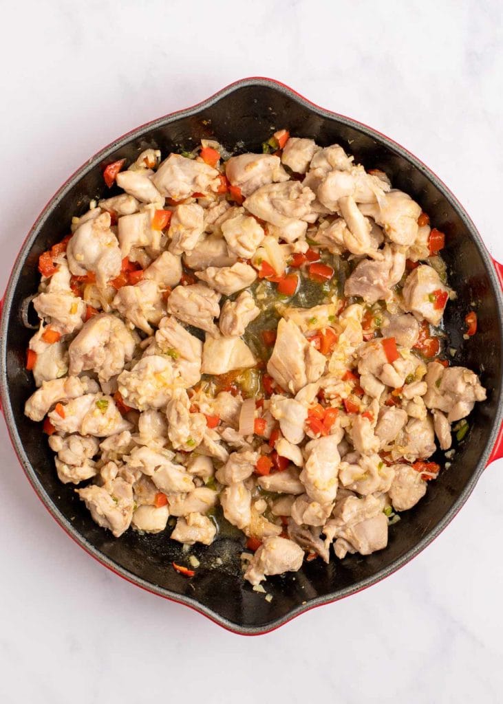 sauteed chicken, red pepper, thai chilis, garlic, and scallions in a skillet