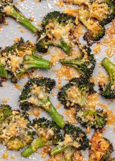 roasted broccoli that is smashed, covered with garlic butter, and sprinkled with cheese
