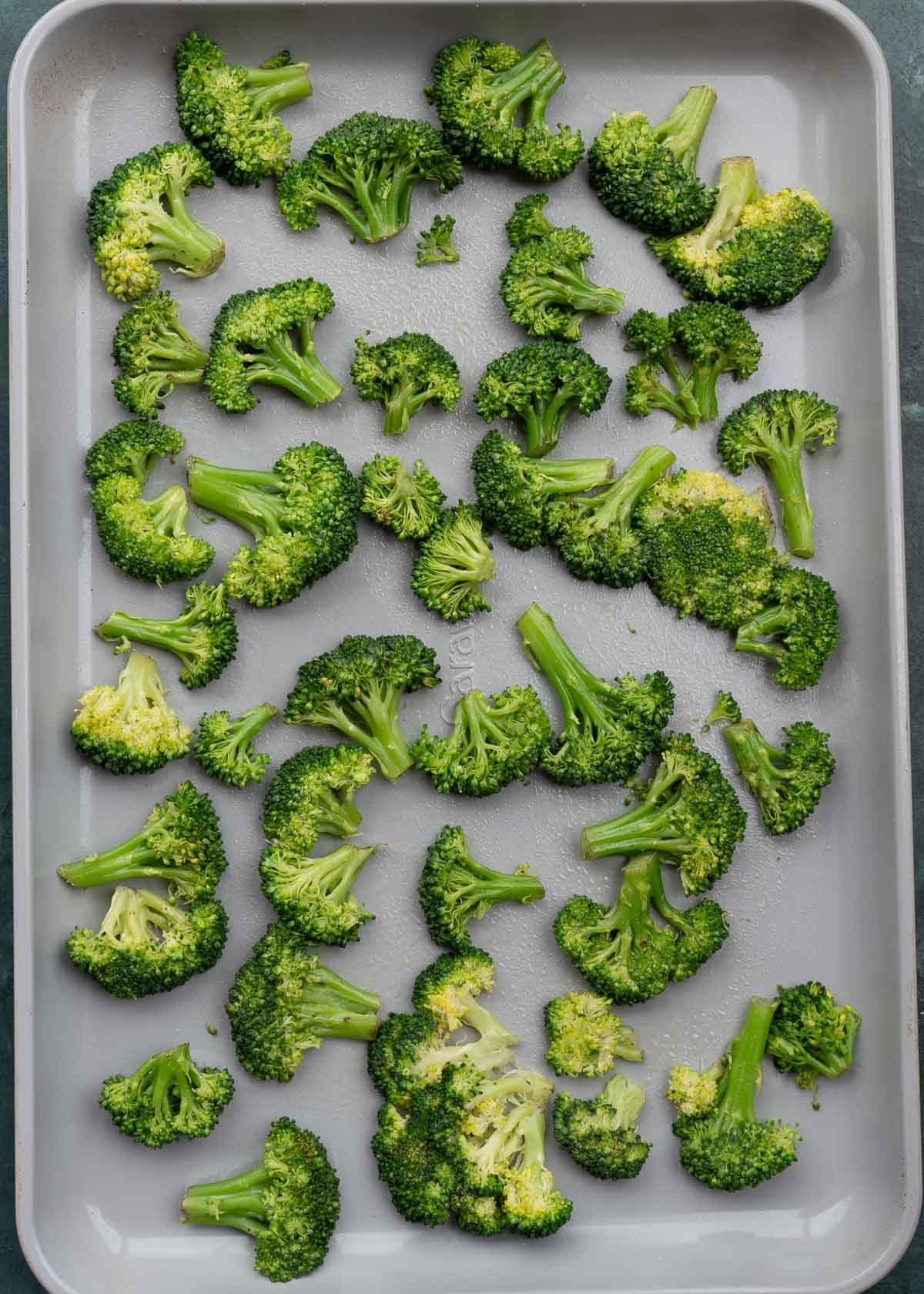steamed broccoli lightly smashed on a baking pan