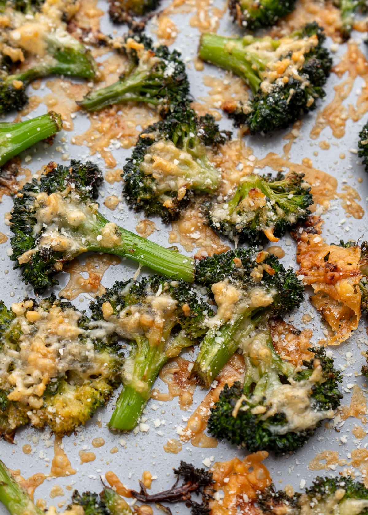 pan full of roasted, smashed broccoli covered with cheese