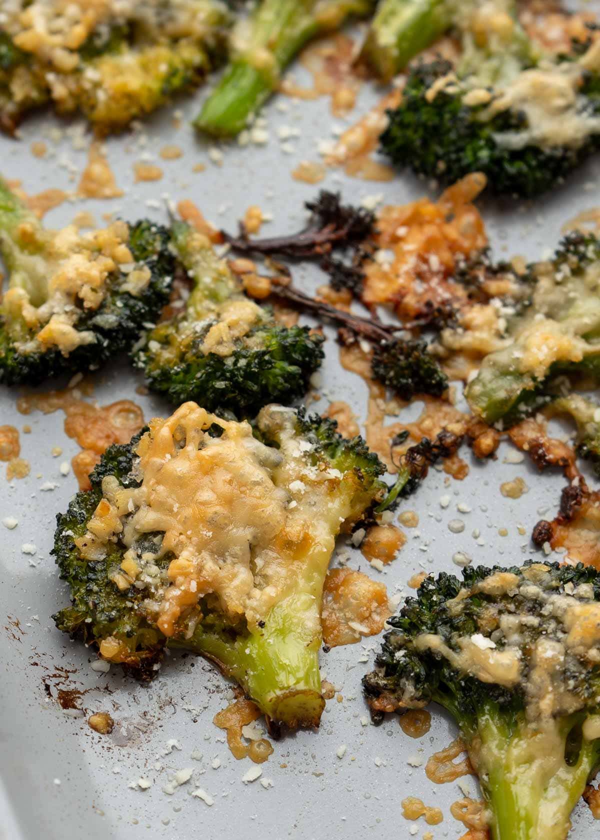 closeup of cheesy smashed broccoli on a pan
