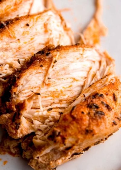 sliced slow cooker chicken breast on white plate