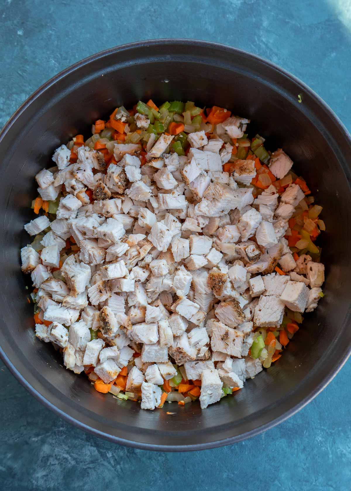 turkey added to sauteed veggies in a pot