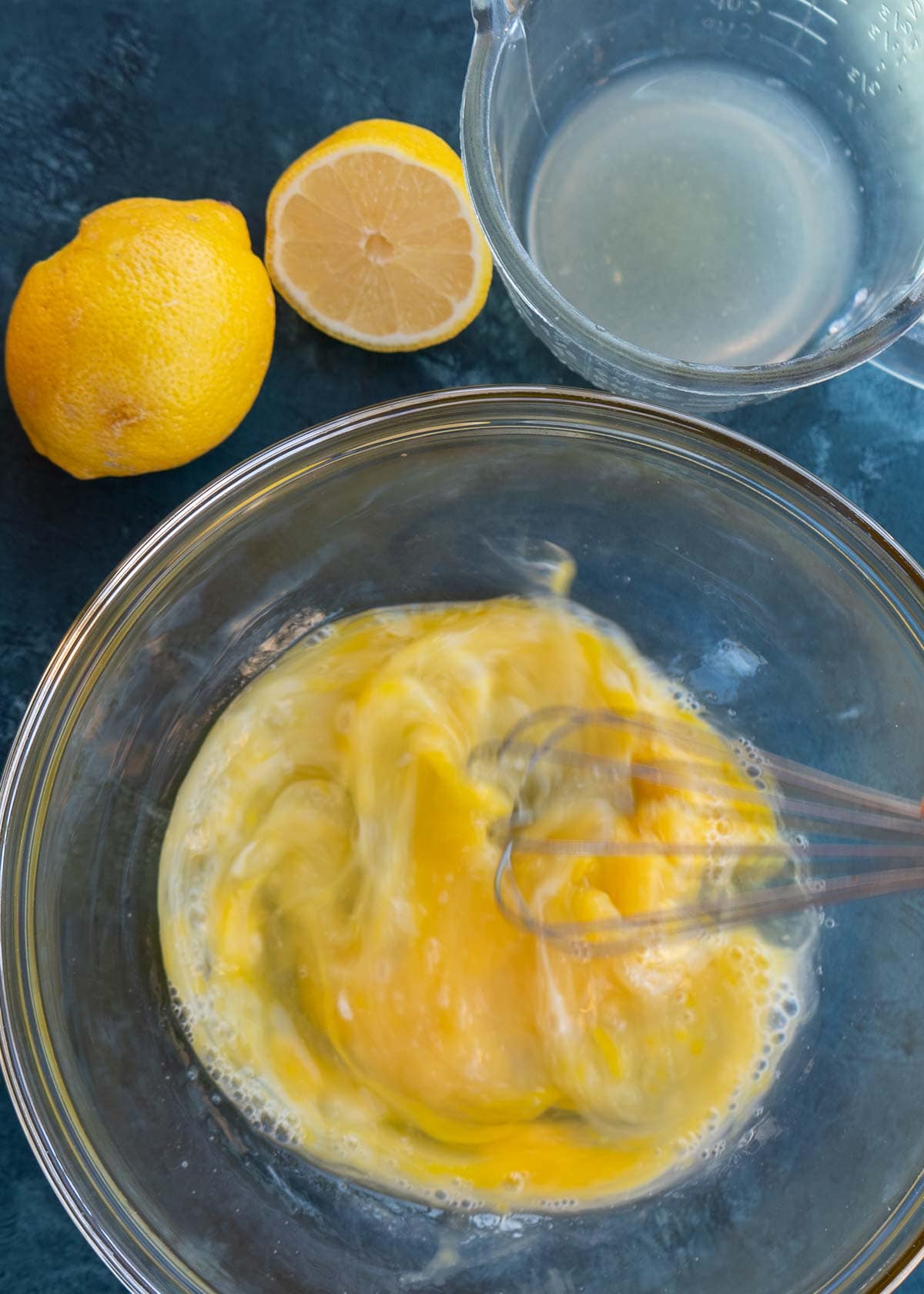 eggs and lemon juice being whisked in a bowl