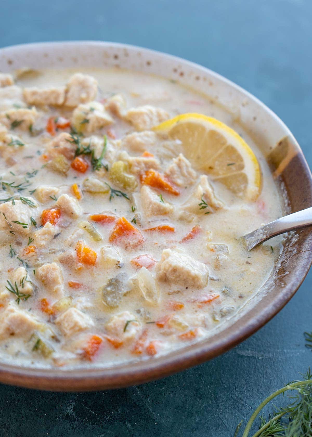 dairy-free turkey soup in a bowl with a lemon wedge