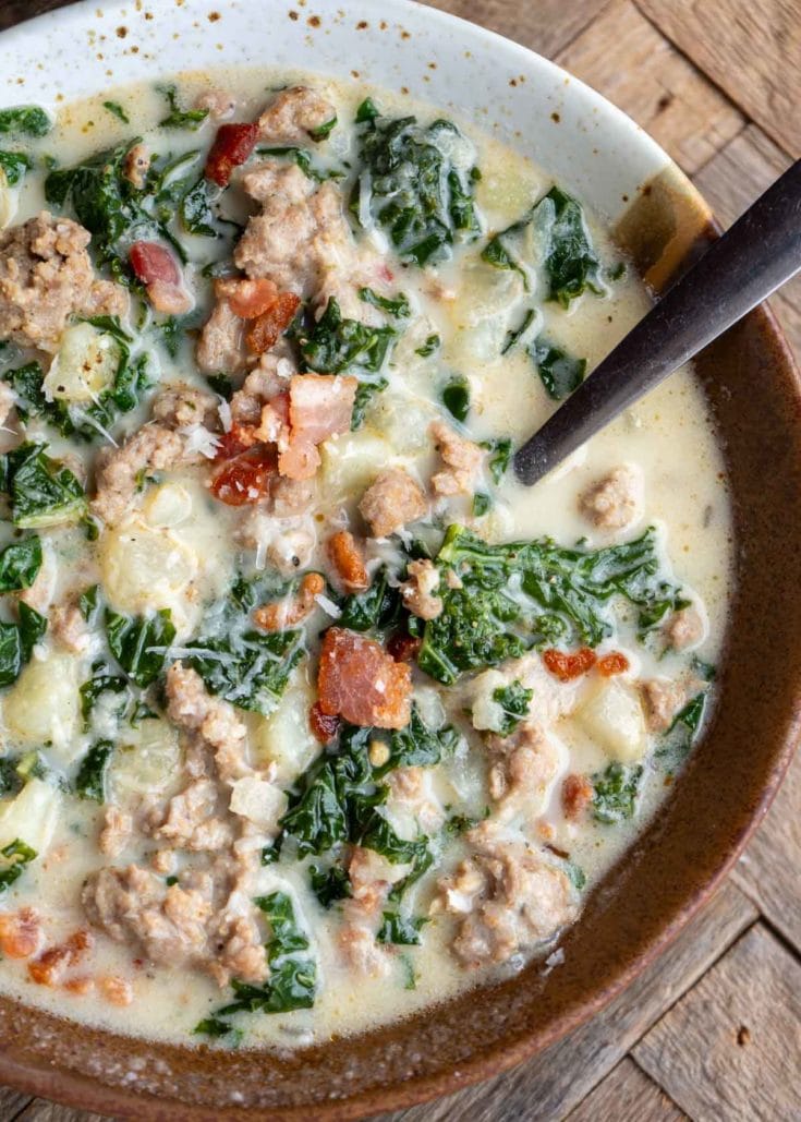 an overhead shot of zuppa toscana in a bowl with a spoon