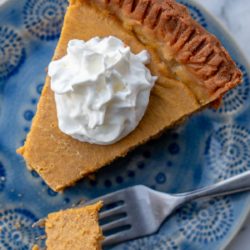 an overhead shot of a slice of keto pumpkin pie with whipped cream