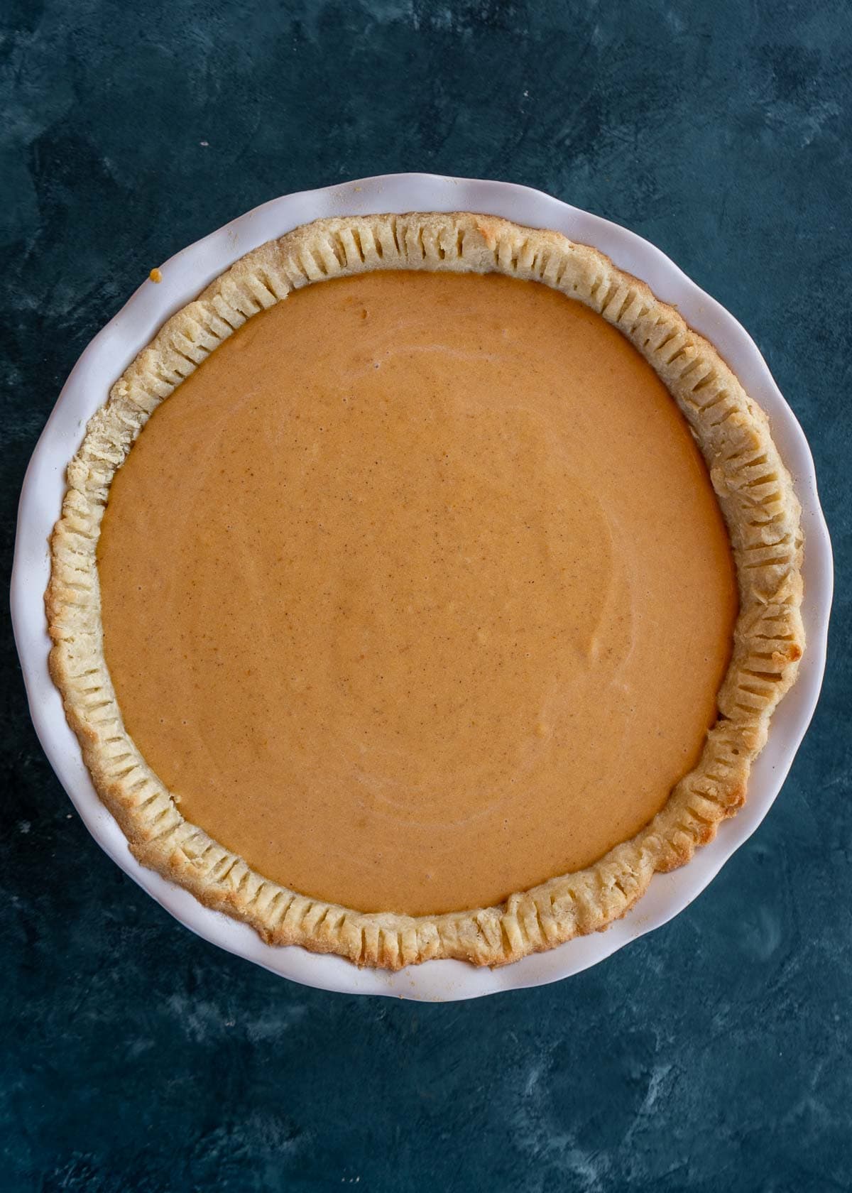 overhead shot of pumpkin pie before being baked