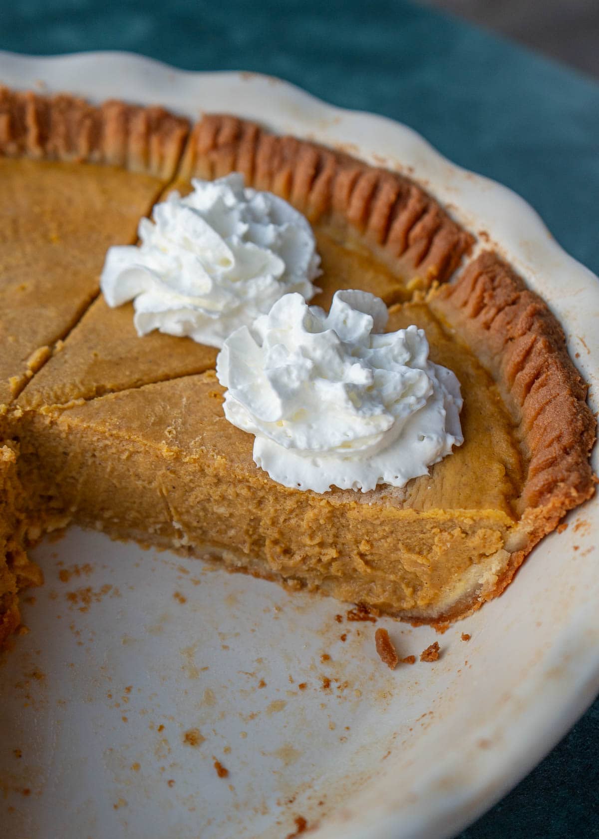 a side angle of slices of pumpkin pie in a pie pan