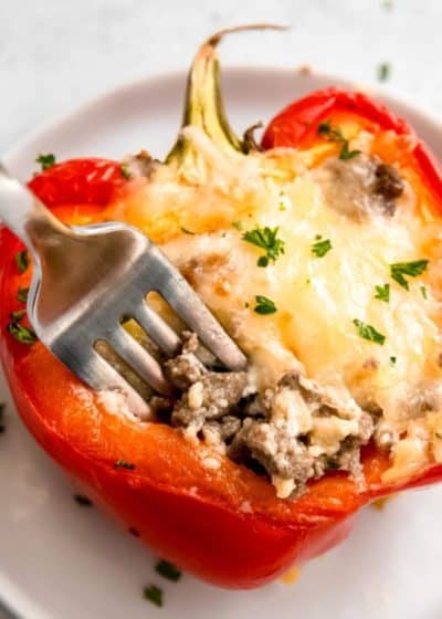 close up of breakfast stuffed bell pepper on white plate with fork
