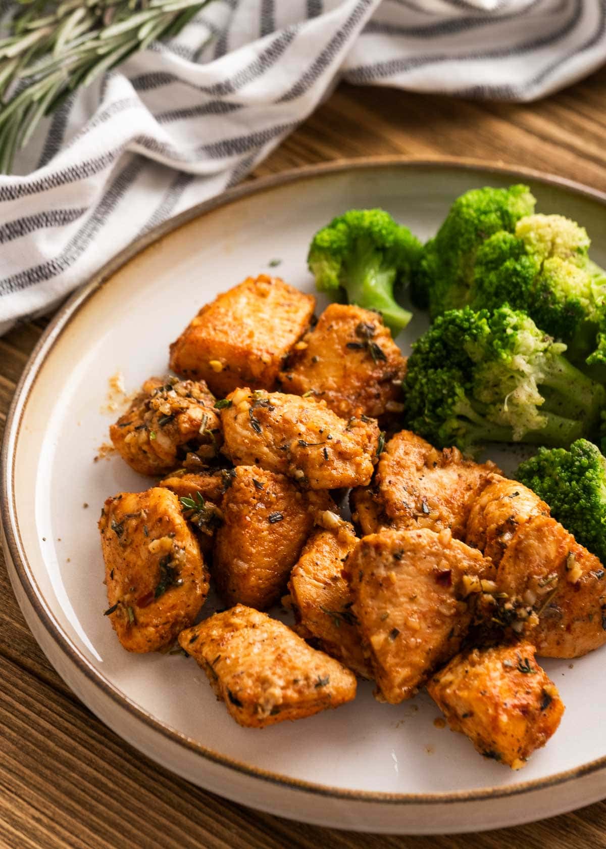garlic butter chicken bites and broccoli on a white plate