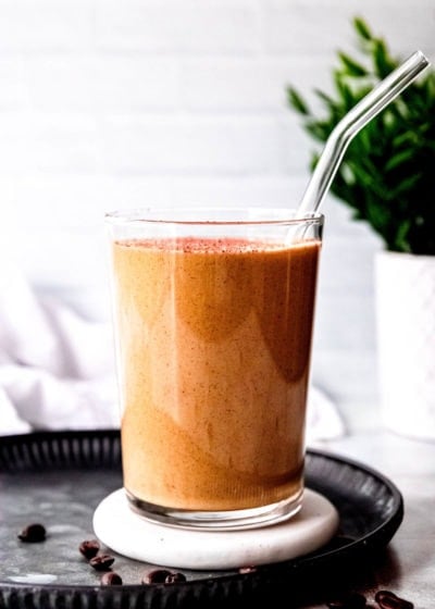 a keto smoothie with coffee and peanut butter in a glass with a clear straw