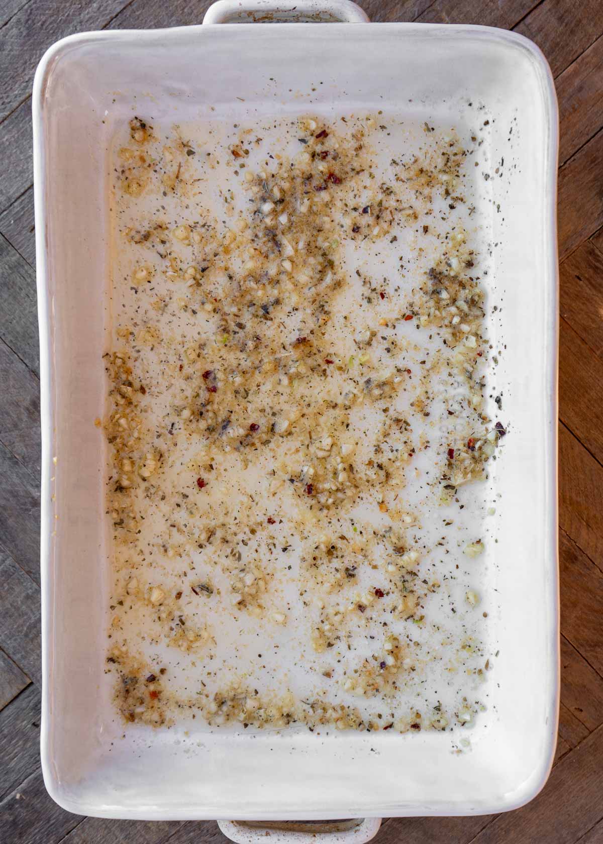 a casserole dish with garlic butter and spices